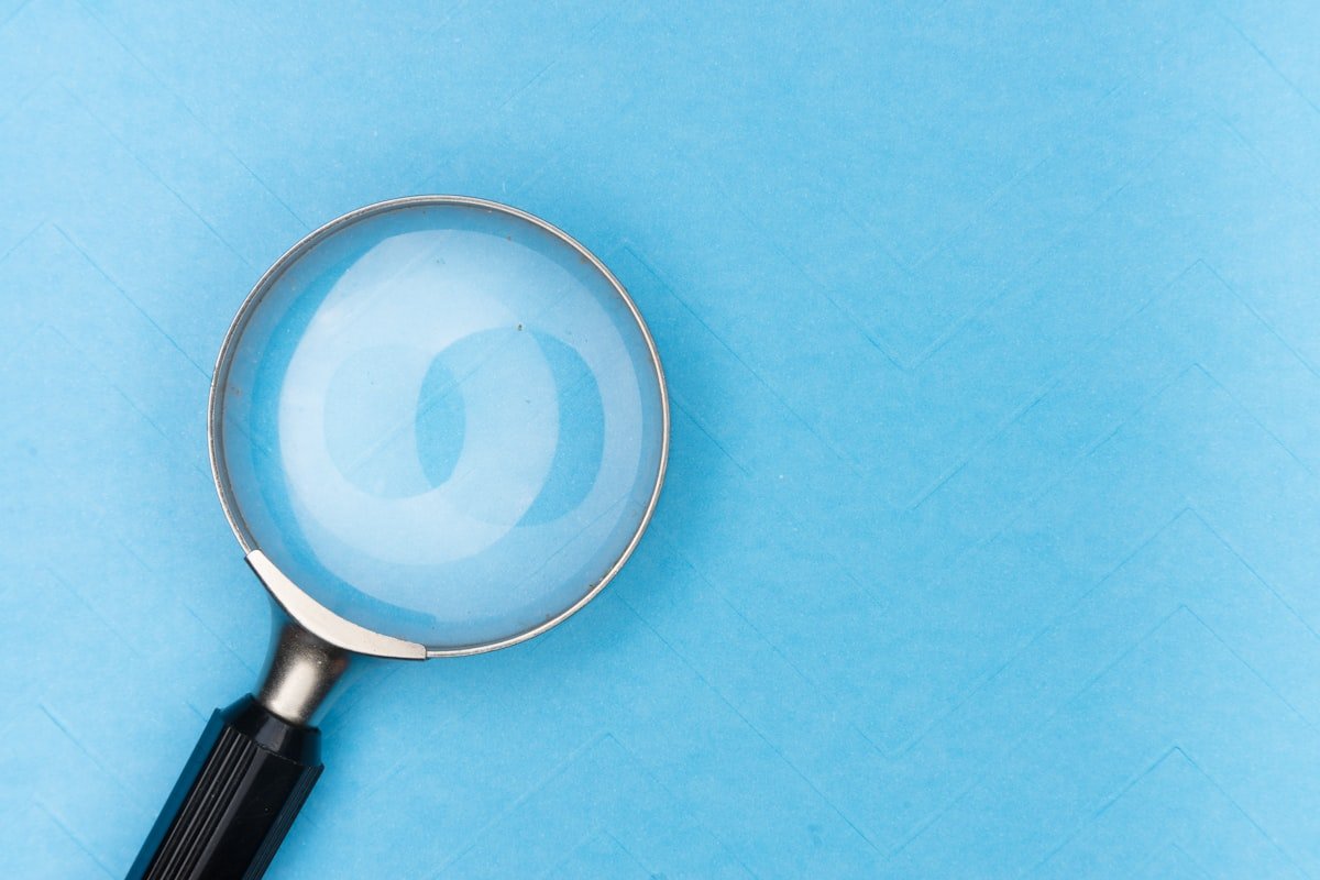 Keyword research for SEO with a magnifying glass over a search and analytics workspace